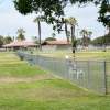 The eastern fence of OB Dog Park and the roof-topped picnic area